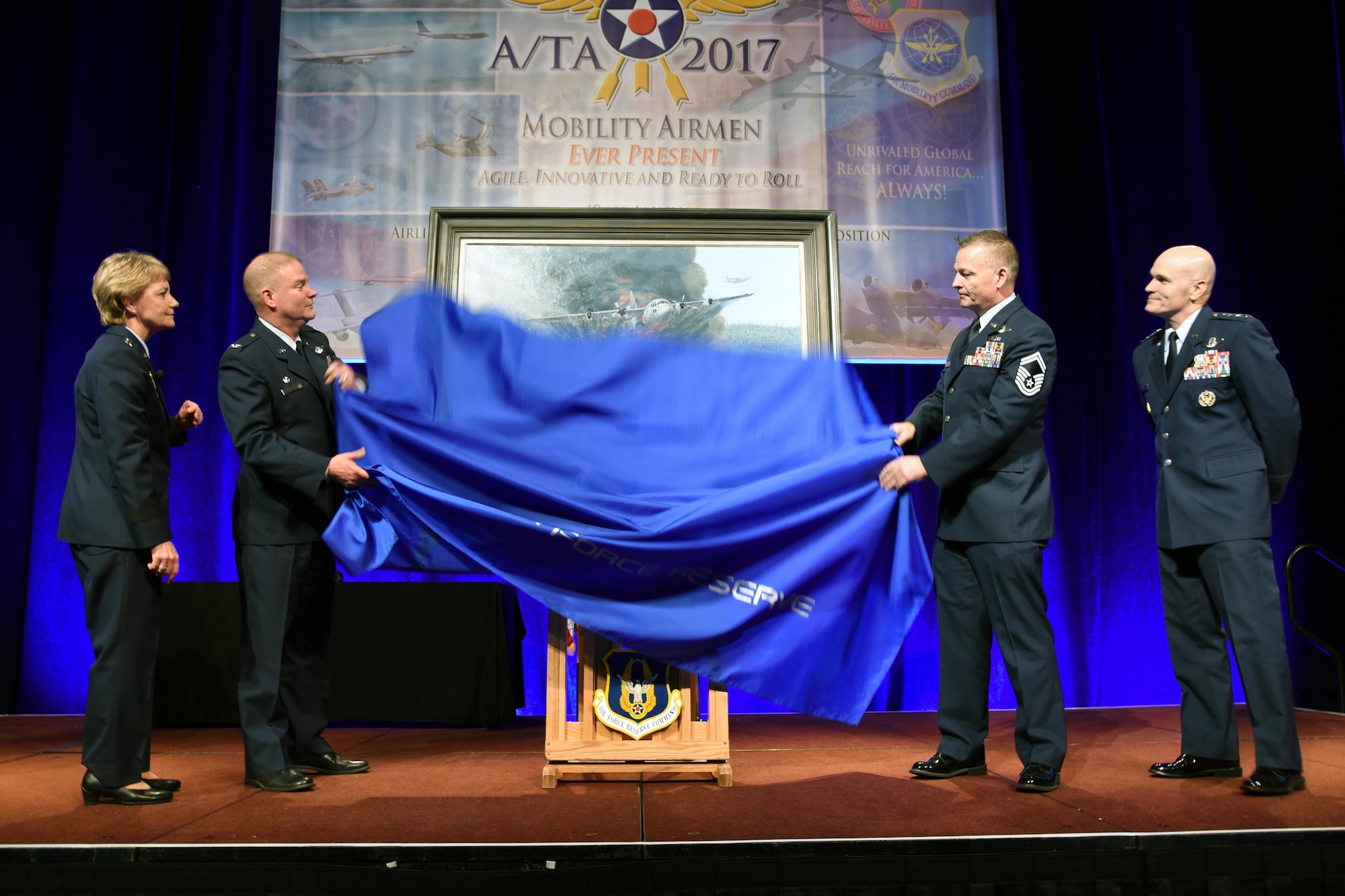 (From Left to right) Lt. Gen. Maryanne Miller, chief of the Air Force Reserve and commander of Air Force Reserve Command, Col. James Devere, 302nd Airlift Wing commander, Senior Master Sgt. Darby Perrin, artist, and Gen. Carlton D. Everhart II, commander of Air Mobility Command unveiled the painting "Earth, Blood and Fire" at the 49th annual Air Mobility Command and Airlift/Tanker Association Symposium in Orlando, Florida. The painting depicts the Modular Airborne Fire Fighting Systems mission of the 731st Airlift Squadron, 302 AW, Peterson Air Force Base, Colorado. (U.S. Air Force photo by Tech. Sgt. Peter Dean)