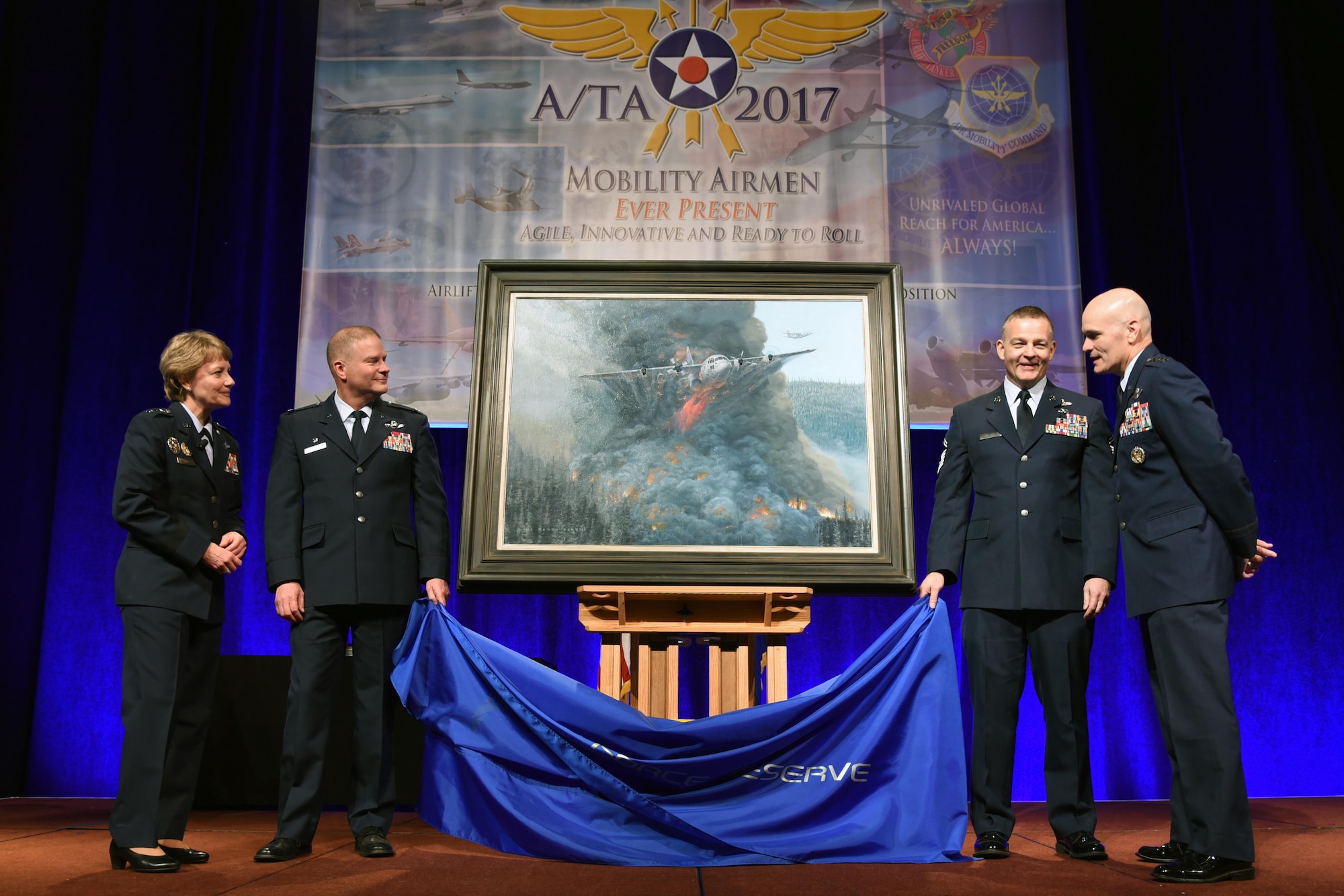(From Left to right) Lt. Gen. Maryanne Miller, chief of the Air Force Reserve and commander of Air Force Reserve Command, Col. James Devere, 302nd Airlift Wing commander, Senior Master Sgt. Darby Perrin, artist, and Gen. Carlton D. Everhart II, commander of Air Mobility Command unveiled the painting "Earth, Blood and Fire" at the 49th annual Air Mobility Command and Airlift/Tanker Association Symposium in Orlando, Florida. The painting depicts the Modular Airborne Fire Fighting Systems mission of the 731st Airlift Squadron, 302 AW, Peterson Air Force Base, Colorado. (U.S. Air Force photo by Tech. Sgt. Peter Dean)