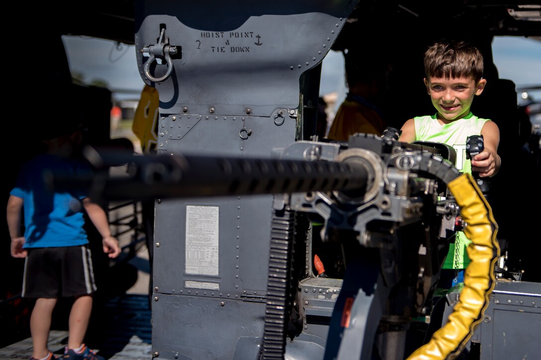 Neal Brooks, son of Staff Sgt. Neal Brooks, 23d Aerospace Medicine Squadron optometry technician, holds the handles of a .50-caliber machine gun, during the Thunder Over South Georgia Air Show, Oct. 28, 2017, at Moody Air Force Base, Ga. The machine gun is attached to an HH-60G Pave Hawk, used in the 23d Wing’s rescue missions. (U.S. Air Force photo by Senior Airman Daniel Snider)