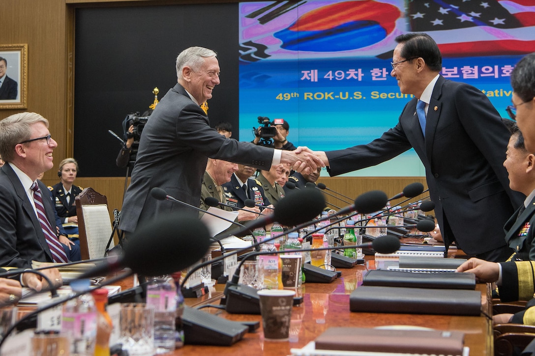 U.S. and South Korean defense leaders shake hands during a security meeting.