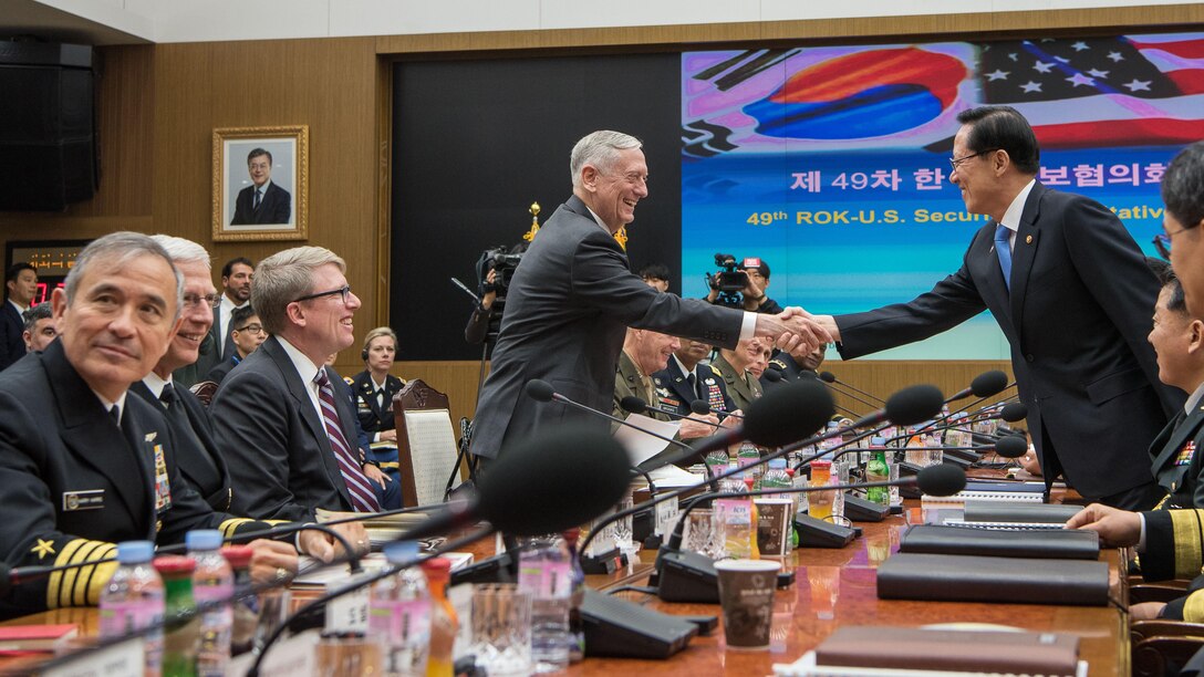 U.S. and South Korean defense leaders shake hands during a security meeting.