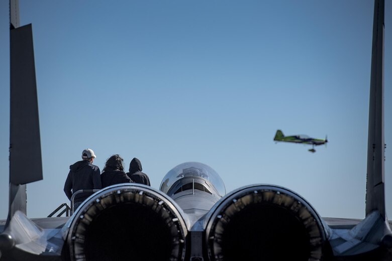 Spectators look on from an F-15 Strike Eagle as Gary Ward flies an MX-2 during the Thunder Over South Georgia Air Show, Oct. 29, 2017, at Moody Air Force Base, Ga. The open house is an opportunity for Moody to thank the local community for all its support, and exhibit air power and it included aerial performances, food, face painting and much more. (U.S. Air Force photo by Staff Sgt. Ryan Callaghan)