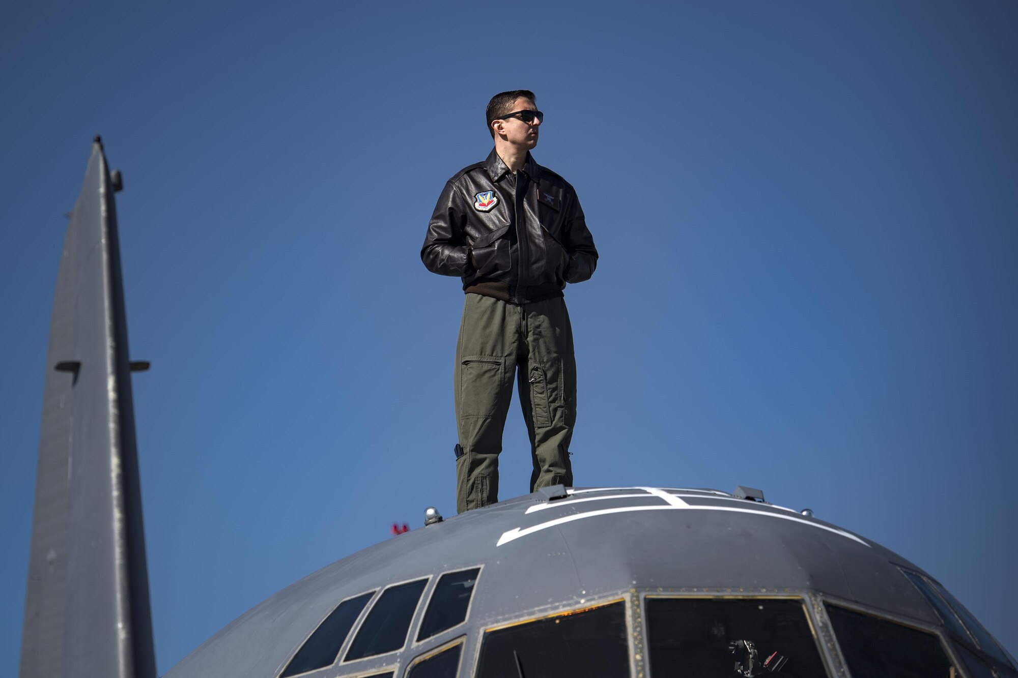 A loadmaster from the 71st Rescue Squadron watches an aerobatic show from the top of an HC-130J Combat King II during the Thunder Over South Georgia Air Show, Oct. 29, 2017, at Moody Air Force Base, Ga. The open house is an opportunity for Moody to thank the local community for all its support, and exhibit air power and it included aerial performances, food, face painting and much more. (U.S. Air Force photo by Staff Sgt. Ryan Callaghan)