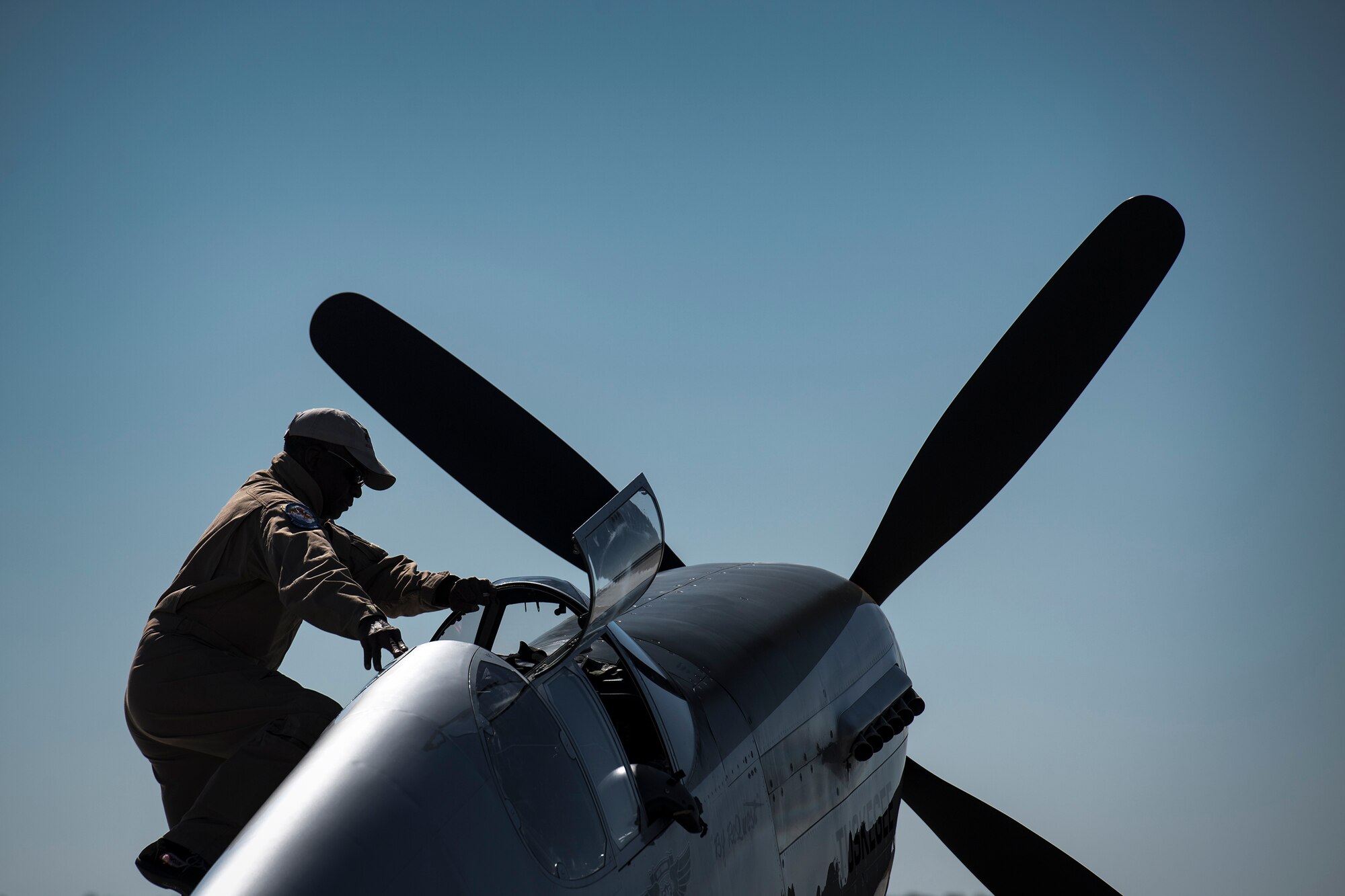 A performer climbs into a P-51 Mustang during the Thunder Over South Georgia Air Show, Oct. 29, 2017, at Moody Air Force Base, Ga. The open house is an opportunity for Moody to thank the local community for all its support, and exhibit air power and it included aerial performances, food, face painting and much more. (U.S. Air Force photo by Staff Sgt. Ryan Callaghan)