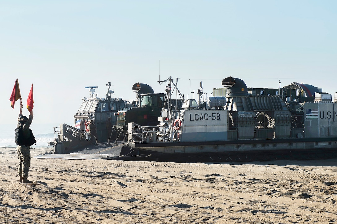 A U.S. sailor participating in bilateral exercise Dawn Blitz 2017 guides an air-cushion landing craft on Red Beach.