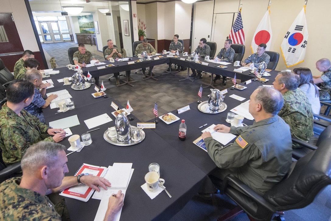 Military leaders sit around a table.