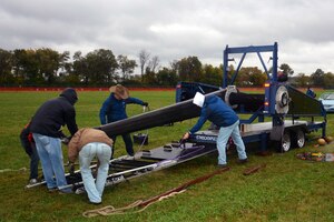 Men prepare a pumpkin chucking machine.