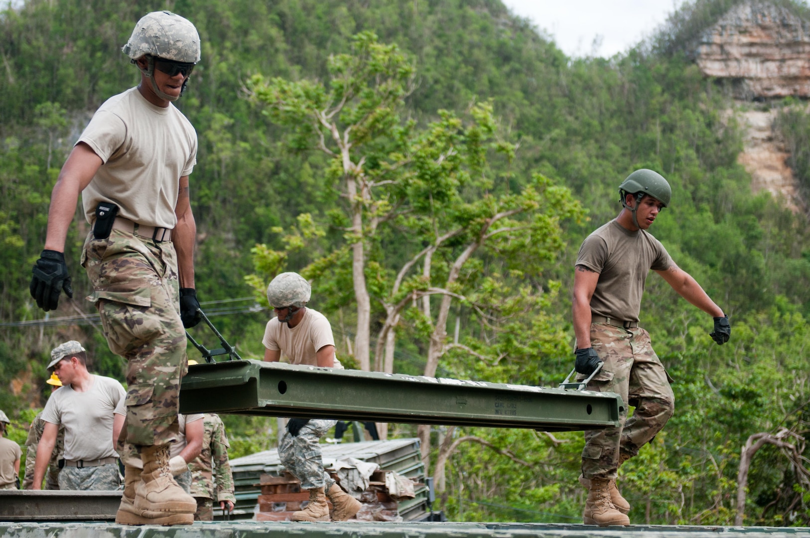 Soldiers with the 892nd Multi-Role Bridge Company, 190th Engineer Battalion from Juncos, Puerto Rico, carry a section of a 40-foot bridge they are building for the citizens of Guajataca, Puerto Rico, October 27.