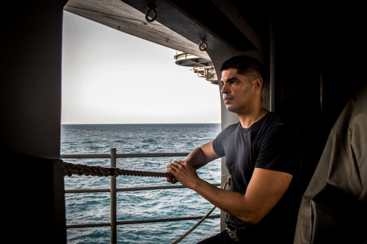 A sailor poses for a photo aboard USS Nimitz in the Persian Gulf.