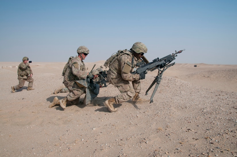 Three soldiers kneeling in the desert.