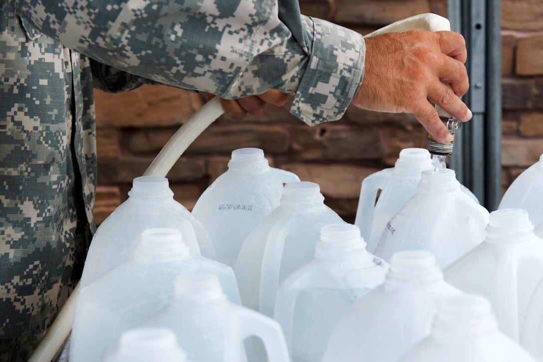Army Sgt. Hector Jimenez prepares water bottles to be distributed in Campo Rico.