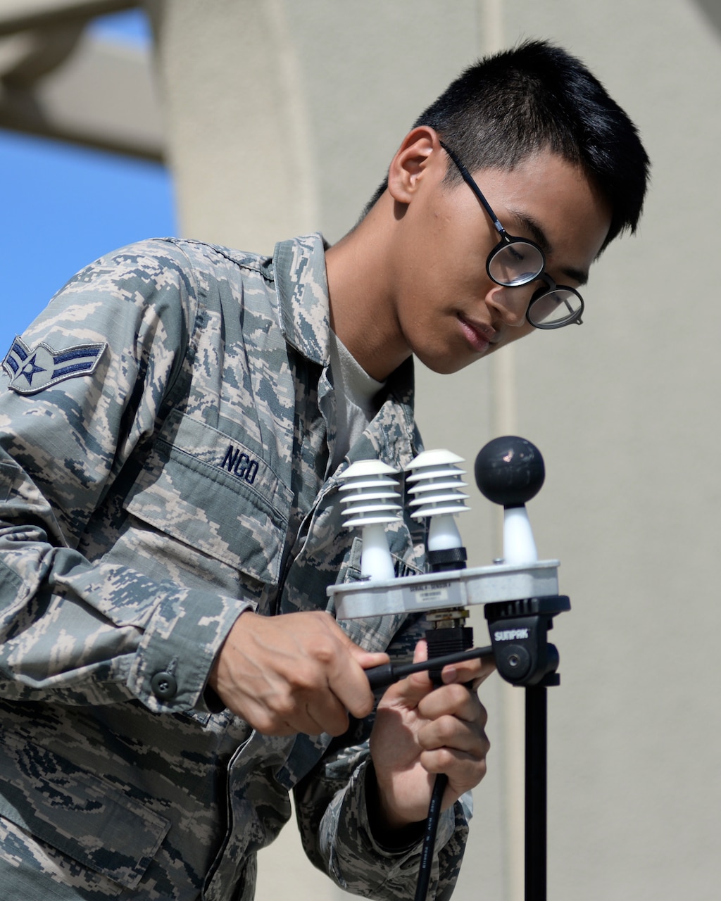 Airman sets up temperature assessment equipment.