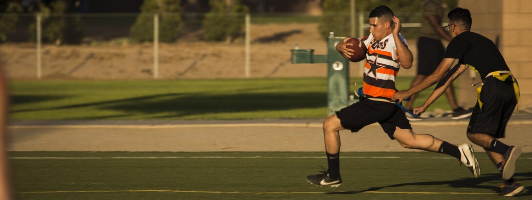 U.S. Marine Corps Cpl. Derycs Miranda, an administrative specialist assigned to Headquarters & Headquarters Squadron (H&HS), rushes towards the end zone during an intramural flag football game against the Marines assigned to Marine Aviation Logistics Squadron (MALS) 13 on Ramada Field at Marine Corps Air Station Yuma, Ariz., Aug. 7, 2017. Miranda scored one of the two touchdowns for H&HS during the game. Intramural flag football is hosted by MCAS Yuma Athletic Department, and is one of the 14 that Marines and Sailors can participate in throughout the year. (U.S. Marine Corps photo taken by Pfc. Sabrina Candiaflores)
