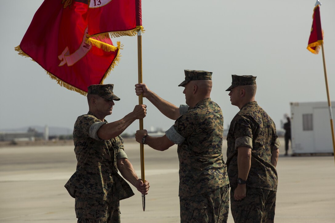 U.S. Marine Corps Sgt. Maj. Jerry Gomes,the Marine Aircraft Group (MAG) 13 sergeant major, passes the colors to the oncoming commanding officer, Col. William R. Sauerland, on the flightline at Marine Corps Air Station Yuma, Ariz., July 28, 2017. Col. Marcus B. Annibale, the outgoing commanding officer of MAG-13, relinquished command to the oncoming commanding officer, Col. William R. Sauerland. (U.S. Marine Corps photo taken by Pfc. Sabrina Candiaflores)