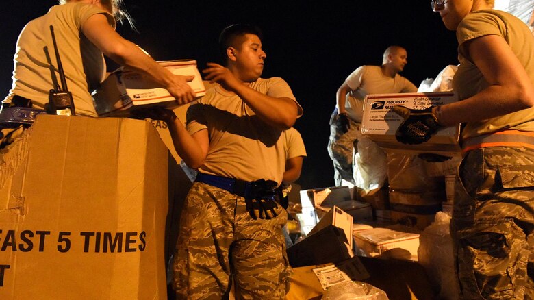 Aerial Port Airmen from Alaska's Air National Guard's 176th Wing, Connecticut ANG's 103rd Airlift Wing and the Puerto Rico ANG's 156th Airlift Wing work together to load 18 pallets of U.S. mail on trucks for the United States Postal Service at Muñiz Air National Guard Base, Puerto Rico, Oct. 20. Power outages and a large influx of care packages and relief items from around the world, have quadrupled the average volume of mail destined to the Caribbean island still in recovery from Hurricane Maria. (U.S. Air National Guard photo by Staff Sgt. Angel Oquendo)
