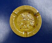 A tin ashtray with Tinker’s name and a B-52 stamped into it.