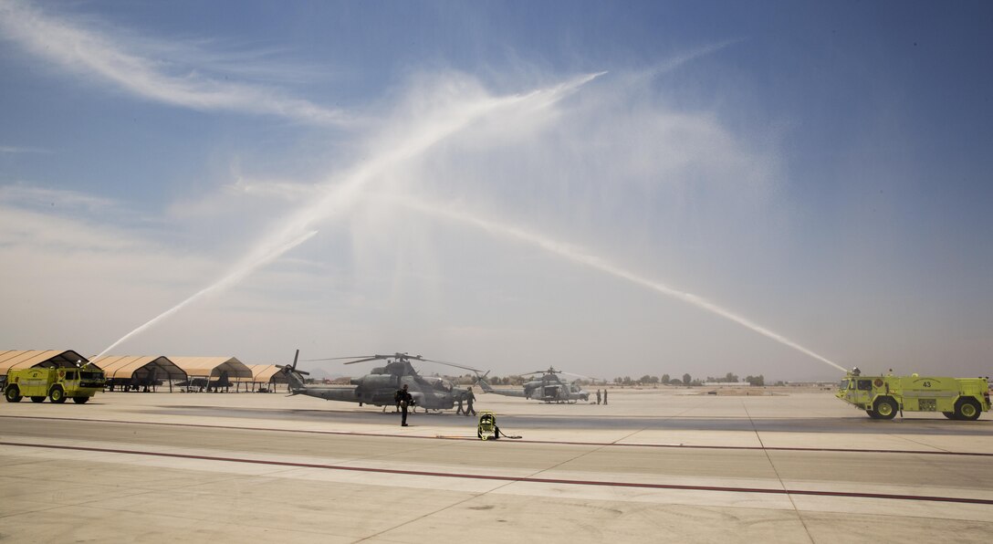 U.S. Marine Corps Maj. Jasmin Moghbeli, a pilot assigned to Marine Test and Evaluation Squadron (VMX) 1, stands by her AH-1 "Cobra" as Marines assigned to Marine Corps Air Station Yuma, Ariz., Aircraft Rescue and Firefighting (ARFF) spray and arch of water as part of a traditional "wet down" July 7, 2017.  Maj. Moghbeli will report to the Johnson Space Center in Houston, Texas, later this year to attend the NASA Astronaut Candidate Class of 2017. (U.S. Marine Corps photo taken by Lance Cpl. Christian Cachola)