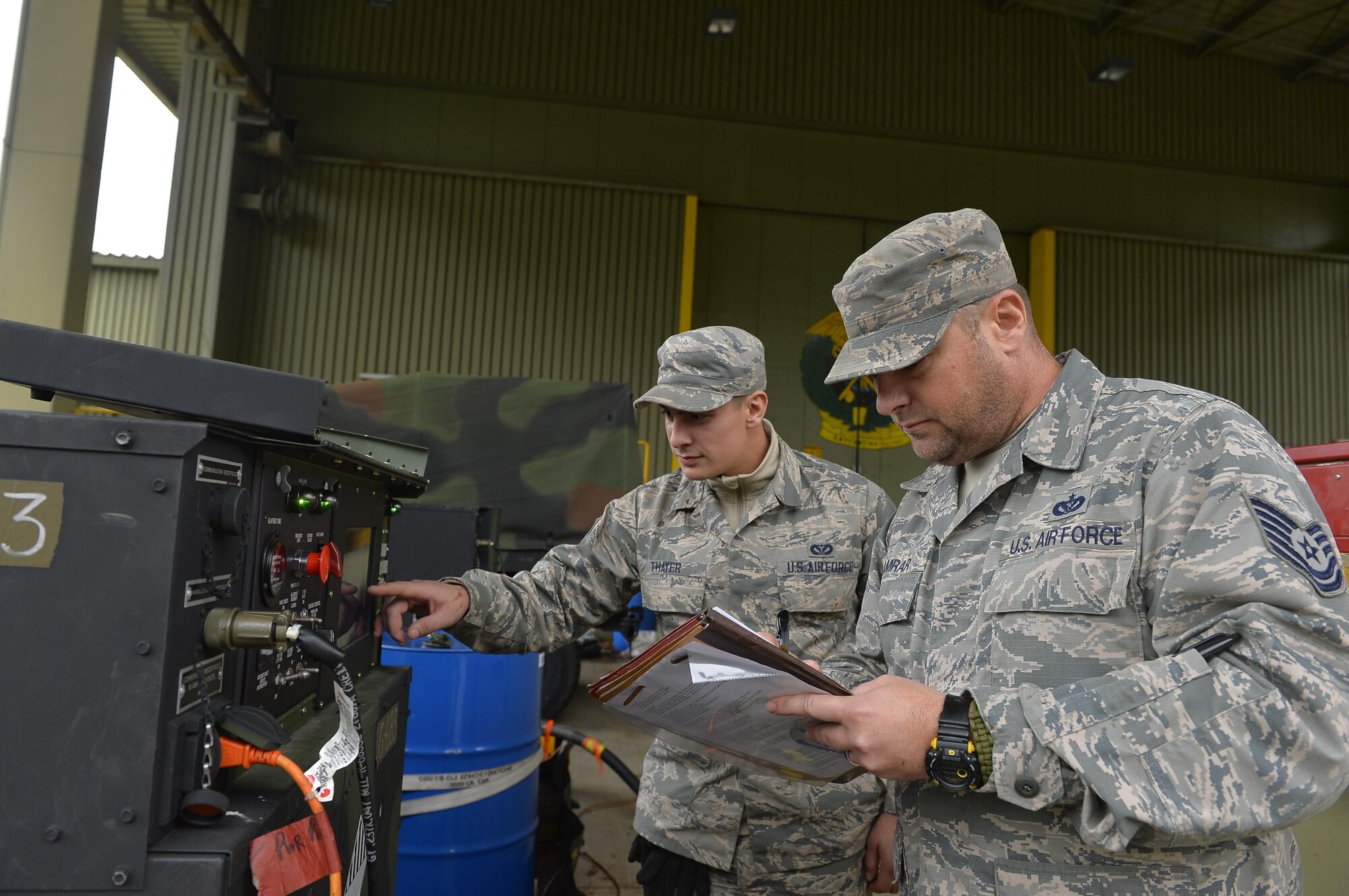 U.S. Air Force Tech. Sgt. James Kamrar, 1st Combat Communications Squadron power production supervisor, right, and Senior Airman Jacob Thayer, 1st CBCS HVAC supervisor, conduct a generator check during an exercise on Rhine Ordnance Barracks, Germany, Oct. 26, 2017. Airmen assigned to the 1st CBCS not only come from the communications career field, but also civil engineers. (U.S. Air Force photo by Airman 1st Class Joshua Magbanua)