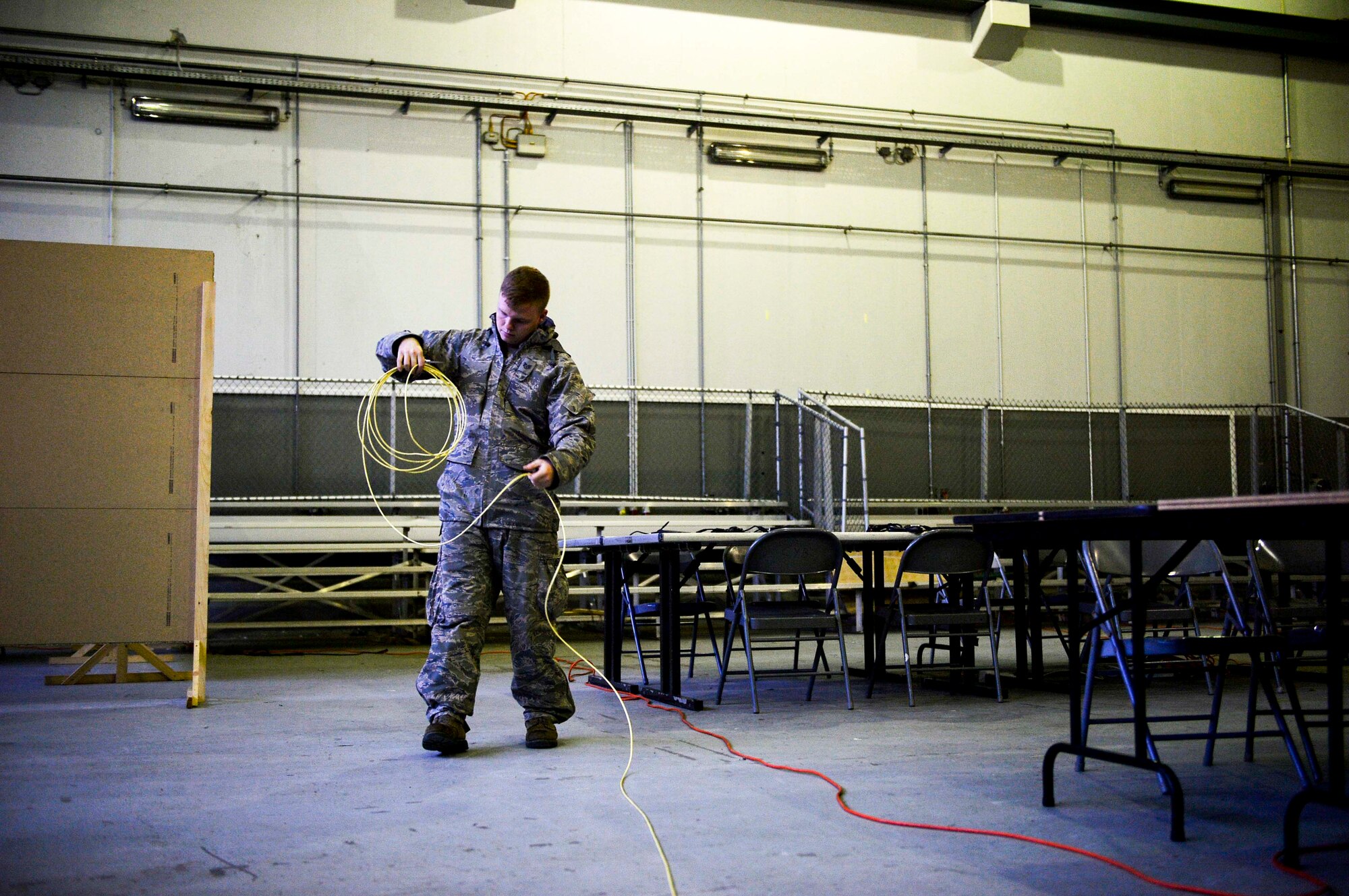 U.S. Air Force Staff Sgt. Jesse Sargent, 1st Combat Communications squadron tactical network operator, measures a chord to make a cable during an exercise on Rhine Ordnance Barracks, Germany, Oct. 26, 2017. Participants in the training event emphasized competence in mission readiness, whether in exercises or real-world operations. (U.S. Air Force photo by Airman 1st Class Joshua Magbanua)