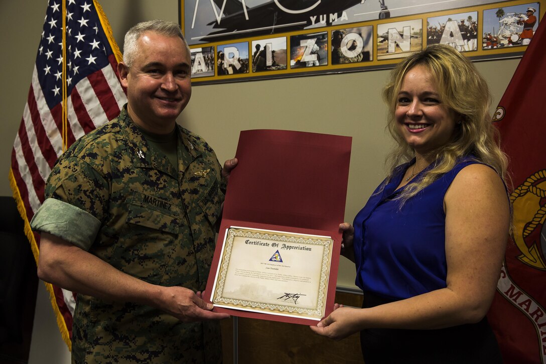 U.S. Marine Corps Col. Ricardo Martinez, the commanding officer of Marine Corps Air Station Yuma, Ariz., recognizes Lisa Tourtelot, the public affairs assistant for MCAS Yuma Public Affairs and Combat Camera, as the MCAS Yuma Employee of the 2nd Quarter, May 3, 2017. (U.S. Marine Corps photo taken by Lance Cpl. Christian Cachola)