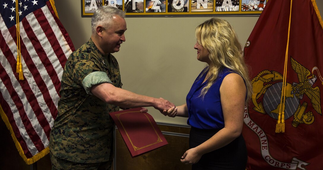 U.S. Marine Corps Col. Ricardo Martinez, the commanding officer of Marine Corps Air Station Yuma, Ariz., recognizes Lisa Tourtelot, the public affairs assistant for MCAS Yuma Public Affairs and Combat Camera, as the MCAS Yuma Employee of the 2nd Quarter, May 3, 2017. (U.S. Marine Corps photo taken by Lance Cpl. Christian Cachola)
