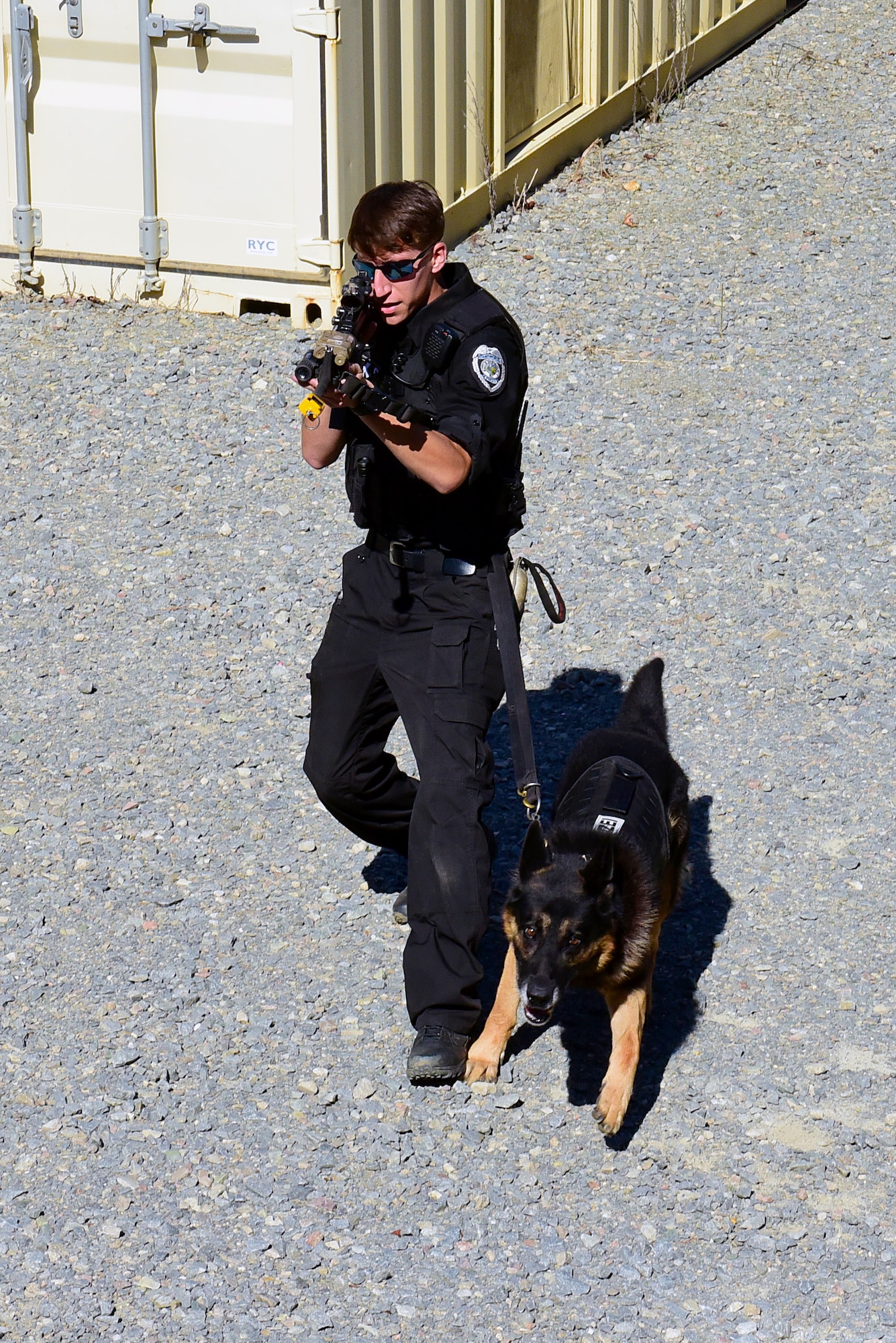 Terry Williams, Stantonsburg Police Department canine officer, and Aaron, police working dog, pursue a simulated suspect in a high-risk patrol scenario during the East Coast Iron Dog competition, Oct. 25, 2017, at Seymour Johnson Air Force Base, North Carolina. During the scenario, the officer exchanged simulated fire with a suspect, followed him into a house, and released the canine to take him down. (U.S. Air Force photo by Airman 1st Class Kenneth Boyton)