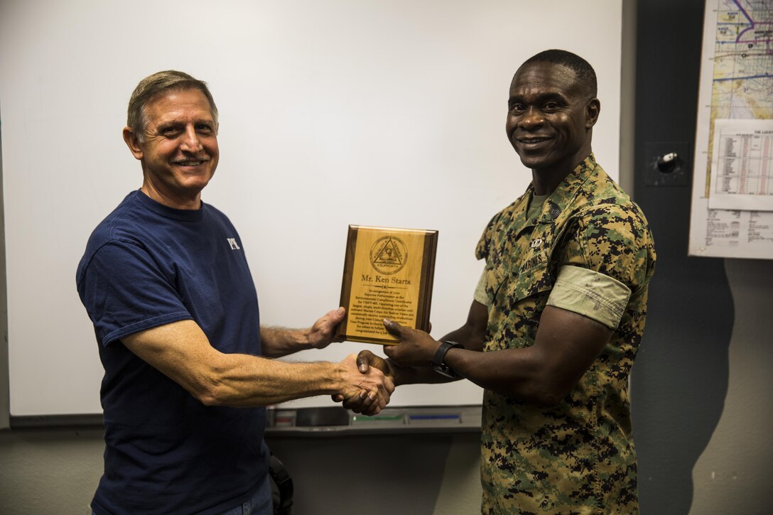 U.S. Marine Corps Sgt. Maj. Delvin Smythe, the sergeant major of Marine Corps Air Station Yuma, Ariz., congratulates Kenneth Starts, the environmental compliance coordinator with VMFT-401, for his superior performance of duties, Tuesday, April 18, 2017. Starts manages 46 designated waste streams, 746 items of hazardous material and consistently receives outstanding marks with no discrepancies on his Annual Environmental Compliance Inspections.