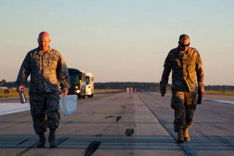 Lt. Col. Daniel Wilson, 23d Maintenance Group deputy commander, left, and Lt. Col. Chris Dunston, 723d Aircraft Maintenance Squadron commander, walk along the flight line looking for trash during a foreign object debris (FOD) walk, Oct. 30, 2017, at Moody Air Force Base, Ga. The FOD walk was performed following the Thunder Over South Georgia Air Show, to remove any debris that could potentially cause damage to aircraft or vehicles. (U.S. Air Force photo by Airman 1st Class Erick Requadt)