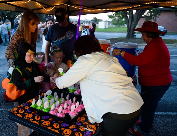 Volunteers distribute cupcakes and drinks to Fall Fest attendees outside the library at Joint Base Charleston, S.C., Oct. 27, 2017.