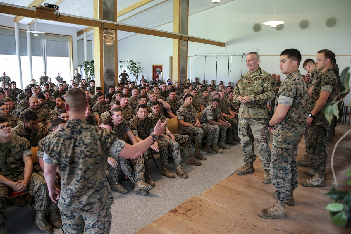 The senior enlisted advisor to the chairman of the Joint Chiefs of Staff listens as a Marine recognizes fellow Marines.