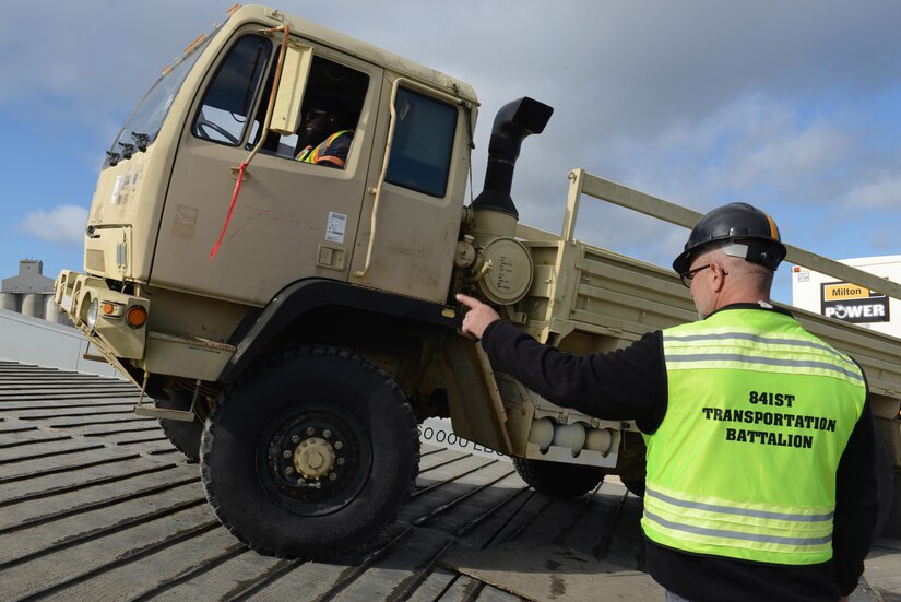 John Wood, 841st Transportation Battalion, 597th Transportation Brigade security coordinator, directs vehicles with generators onto Military Sealift Command’s USNS Brittin at Joint Base Charleston Naval Weapons Station, S.C., Oct. 28, 2017.