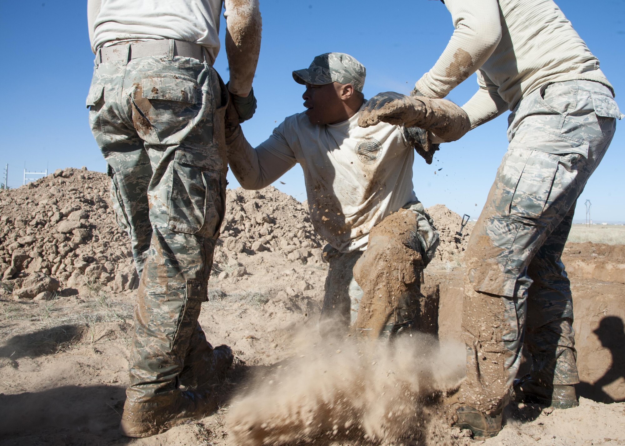 Staff Sgt. Raymond Thompkins 377th Weapons Systems Security Squadron, is assisted out of a five-foot hole by Senior Airmen Cody Ronson and Aaron Wallace, 377th WSSS, during the Manzano Challenge at Kirtland Air Force Base, N.M., Oct. 27. The competition featured Security Forces Airmen from across the 377th Security Forces Group divided into teams of four to compete on 13 stations. (U.S. Air Force photo by Staff Sgt. J.D. Strong II)