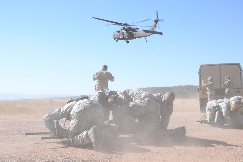 Reserve Citizen Airmen with the 302nd Aeromedical Staging Squadron shield a patient strapped to a litter as a UH-60 Black Hawk helicopter kicks up dust while landing at Fort Carson’s Camp Red Devil training area during a joint  exercise in Colorado Springs, Colo., Oct. 14, 2017.
