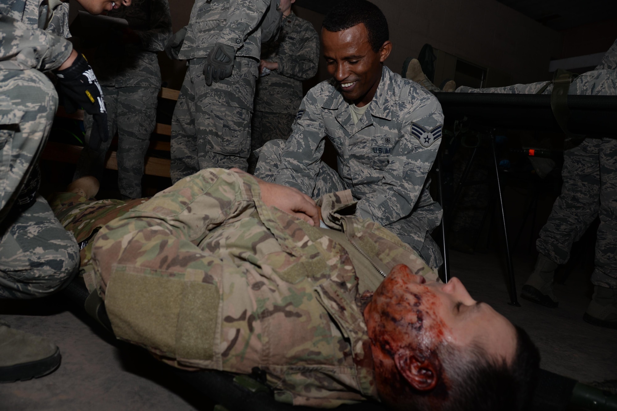 Senior Airman Mehader Teferi, a 302nd Aeromedical Staging Squadron medical technician, provides simulated emergency medical care to Tech. Sgt. William Marks, the 302nd ASTS NCO in charge of biomedical equipment repair who has simulated injuries, as part of an exercise at Fort Carson’s Camp Red Devil training area in Colorado Springs, Colo., Oct. 14, 2017.