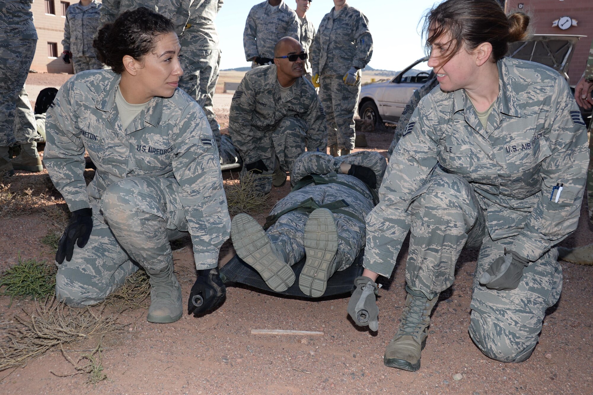Staff Sgt. Barbara Yale and Airman 1st Class is Genevieve Patton, both 302nd Aeromedical Staging Squadron medical technicians, prepare to lift an Airman strapped to a litter during a joint aeromedical  exercise at Fort Carson’s Camp Red Devil training area in Colorado Springs, Colo., Oct. 14, 2017.