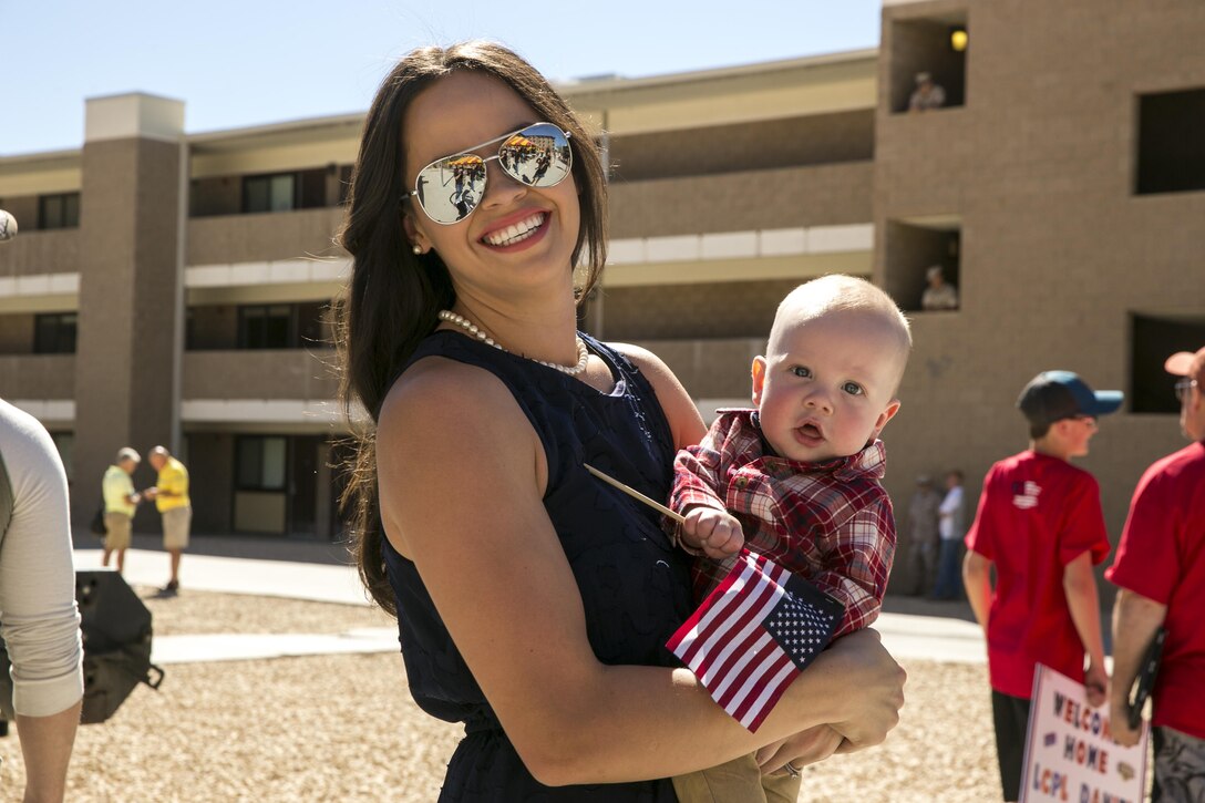 Sarah Gray and her son, Mark Gray Jr., attend the homecoming to welcome back her husband Staff Sgt. Mark Gray, weapons platoon sergeant, Animal Company, 1st Battalion, 7th Marine Regiment, at the 1/7 barracks courtyard aboard the Marine Corps Air Ground Combat Center, Twentynine Palms, Calif., Oct. 22, 2017. The homecoming marked the first day her husband meet their child. (U.S. Marine Corps photo by Pfc. Rachel K. Young)