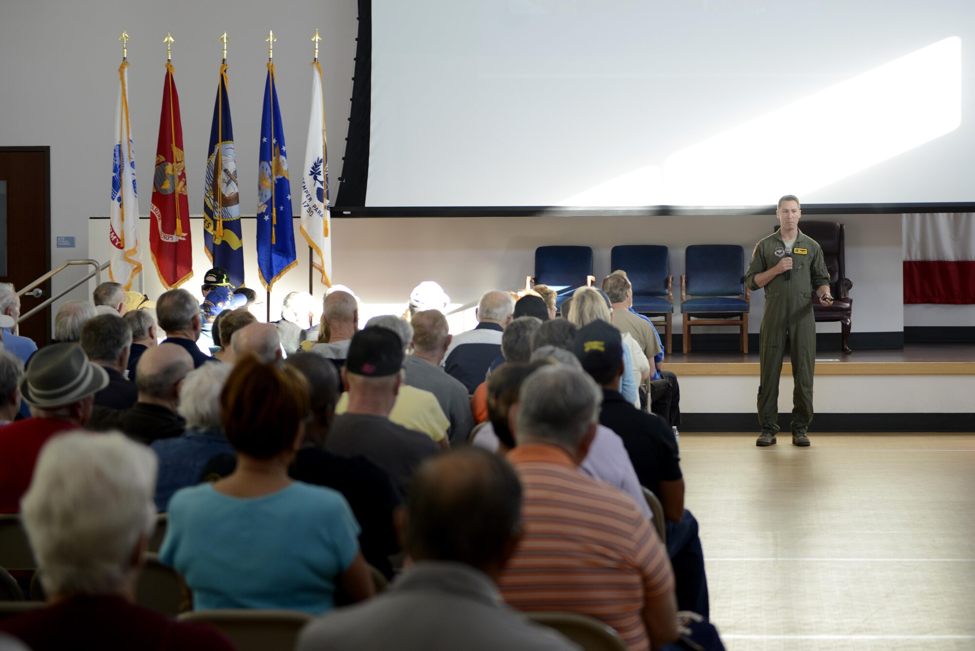 Maj. Ian Osterreicher, 61st Fighter Squadron F-35A Lightning II instructor pilot, gives an F-35 briefing during the Retiree Appreciation Day at Luke Air Force Base, Ariz., Oct. 28, 2017. The brief was held at the Navy Operations Support Center’s main assembly room and focused on the logistics and mechanics of the aircraft. (U.S. Air Force photo/Airman 1st Class Pedro Mota)