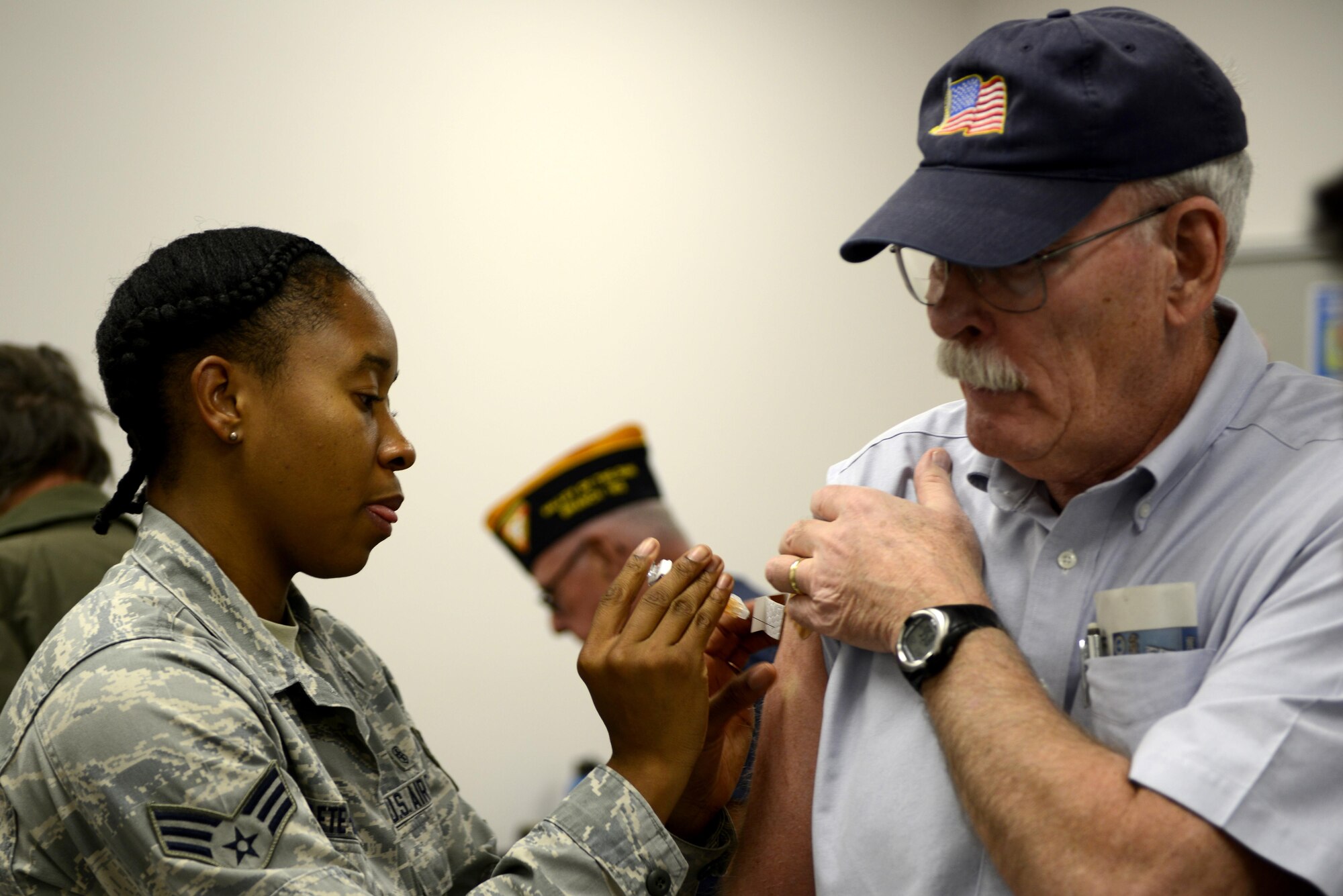 Senior Airman Gisele Adanlete-Engram, 56th Medical Operation Squadron aerospace medical technician, gives a retired service member a flu shot at Luke Air Force Base, Ariz., Oct. 28, 2017. During a Retiree Appreciation Day, the 56th Medical Group offered retirees shots for shingles, flu and pneumonia. (U.S. Air Force photo/Airman 1st Class Pedro Mota)