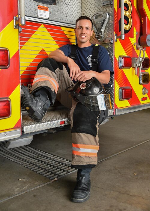 U.S. Air Force Senior Master Sgt. Thomas Turner, 153rd Airlift Wing first sergeant, sits on the back of a fire truck.