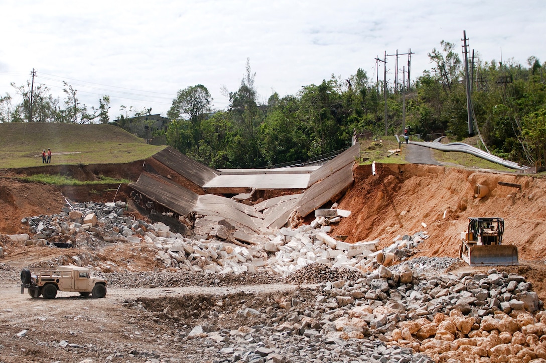 Guardsmen drive a Humvee through the Guajataca Dam’s damaged spillway to the site of a 40-foot bridge they’re building.