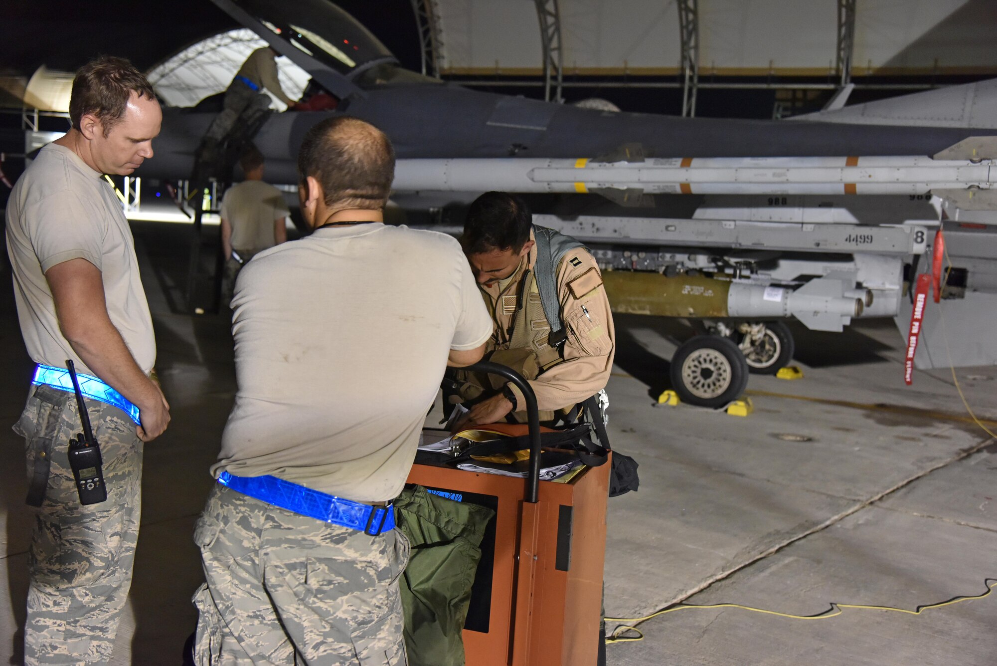 An F-16 Fighting Falcon pilot fills out his post flight paperwork at the 407th Air Expeditionary Group in Southwest Asia Oct. 29. The F-16 reached a milestone of 8,000 flying hours, during the night. (U.S. Air Force photo by Staff Sgt. Joshua Edwards/Released)