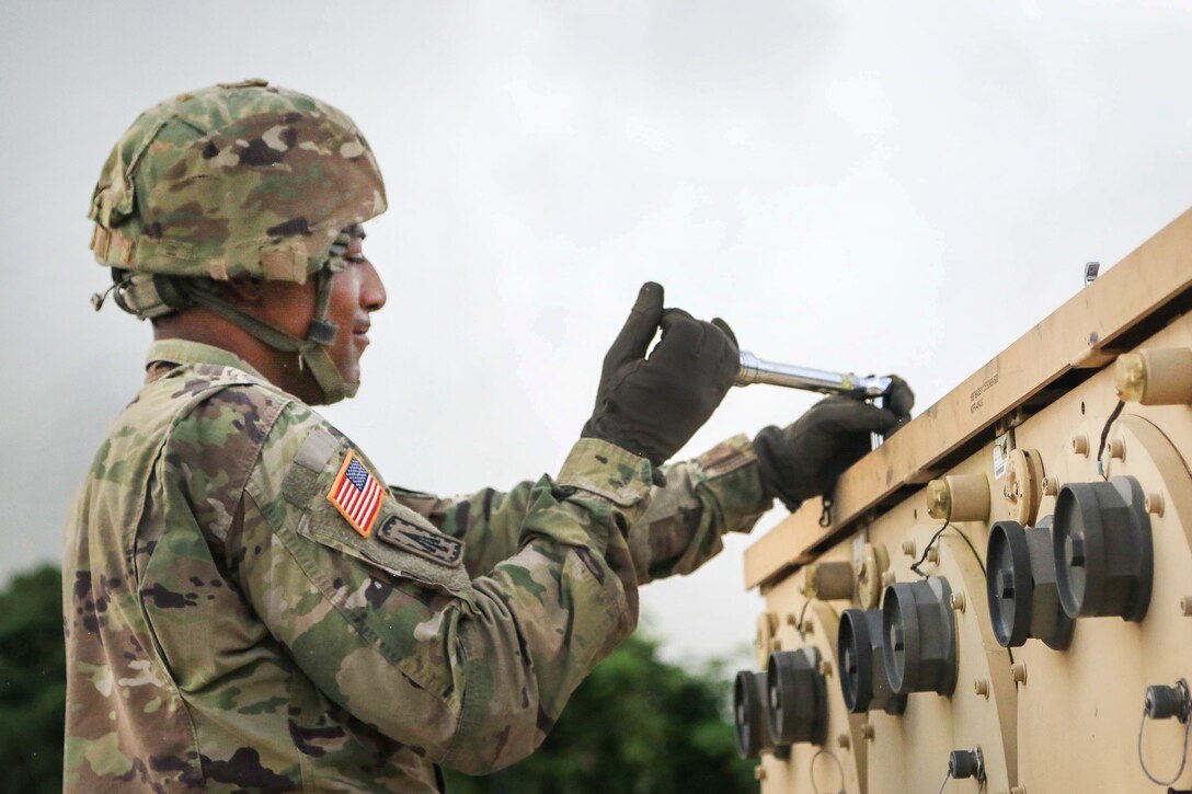 A soldier tightens a bolt on a Terminal High Altitude Area Defense weapon system.