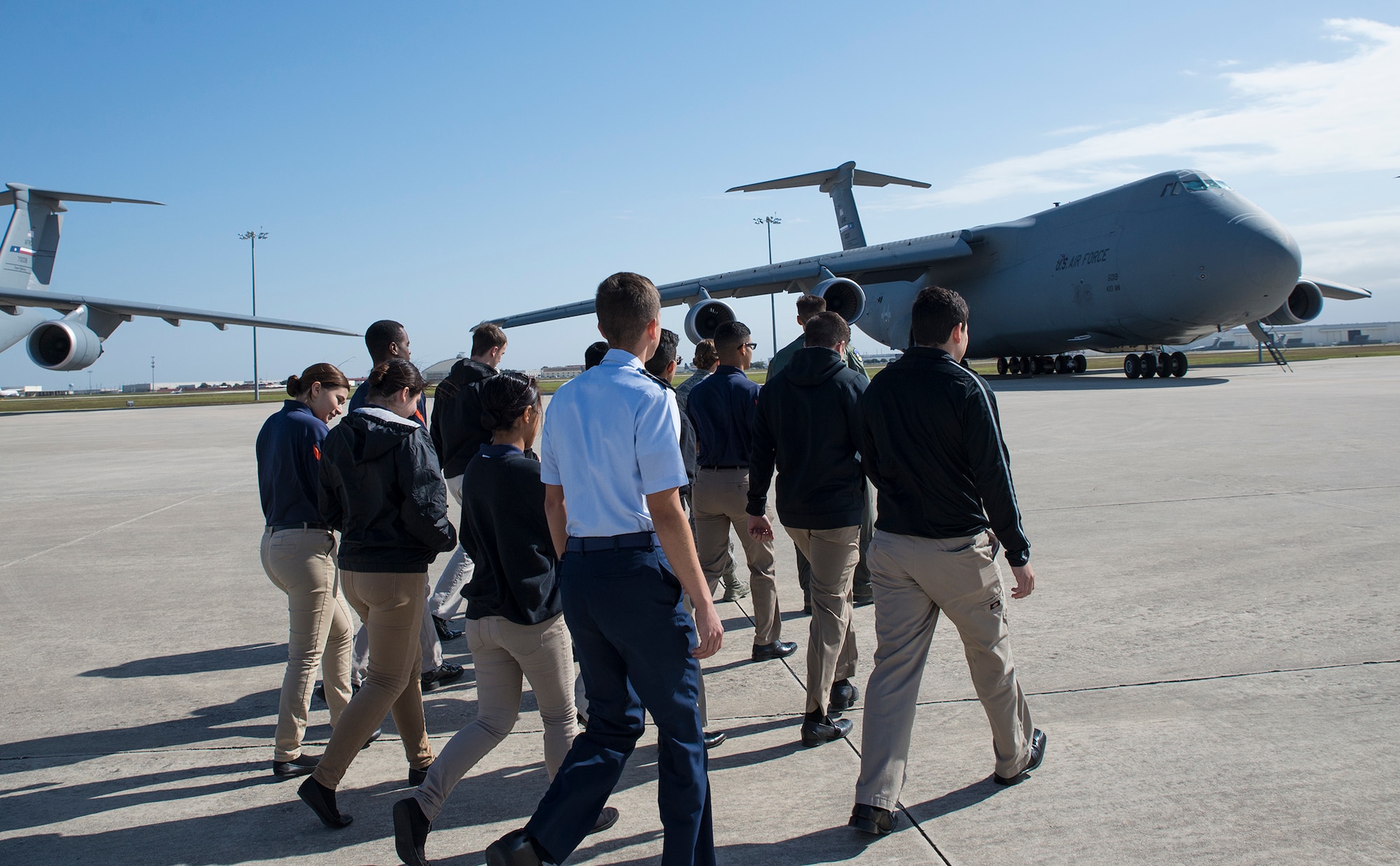 Reserve Officers' Training Corps cadets from the University of Texas at San Antonio walk the flight line before touring a C-5M Super Galaxy aircraft October 27, 2017 at Joint Base San Antonio-Lackland, Texas.