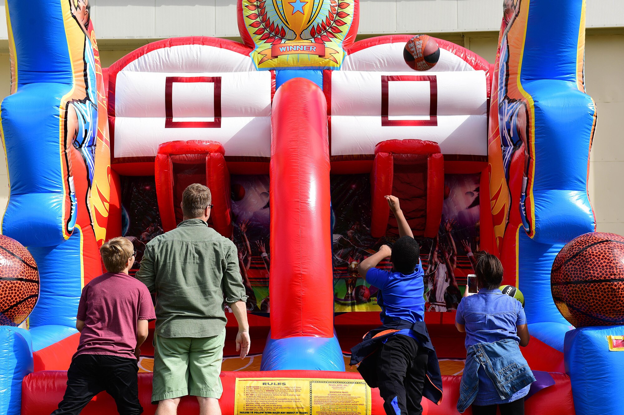 Children playing basketball on an inflatable.