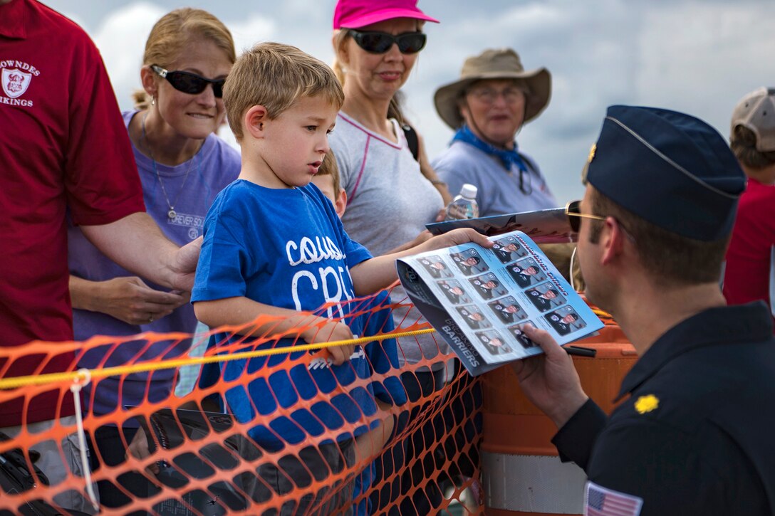 A pilot signs autographs and meets visitors.