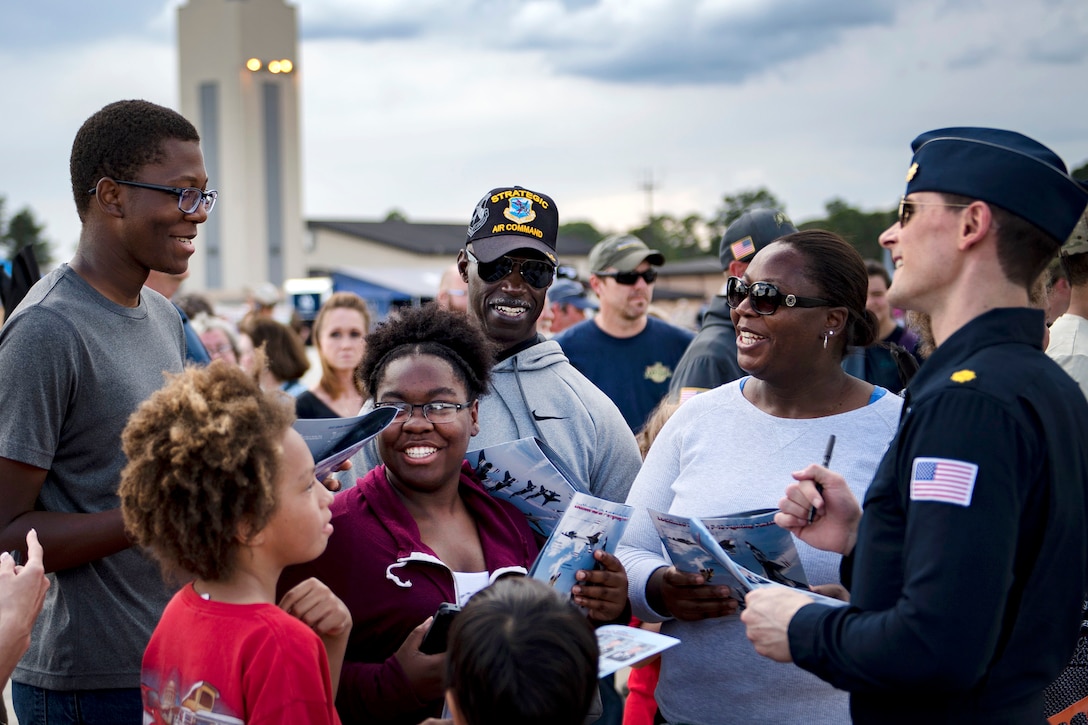 A pilot signs autographs and meets visitors.