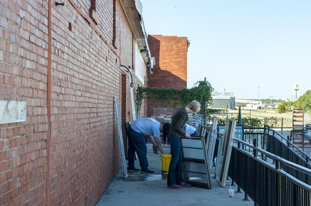 Members of the 17th Communications Squadron repaint window frames and clean the handrails outside of the Habitat for Humanity center in San Angelo, Texas, Oct. 26, 2017. Once a month, the 17th CS pulls together and volunteers, and for October they chose Habitat for Humanity. (U.S. Air Force photo by Senior Airman Scott Jackson/Released)