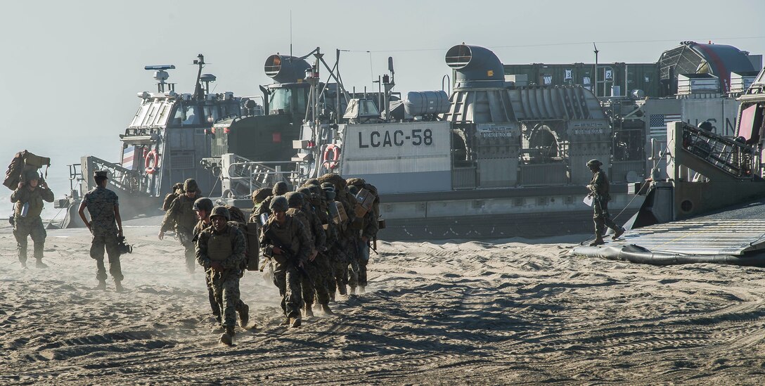 Marines disembark from an air-cushioned landing craft to begin the Red Beach tactical maneuvering.