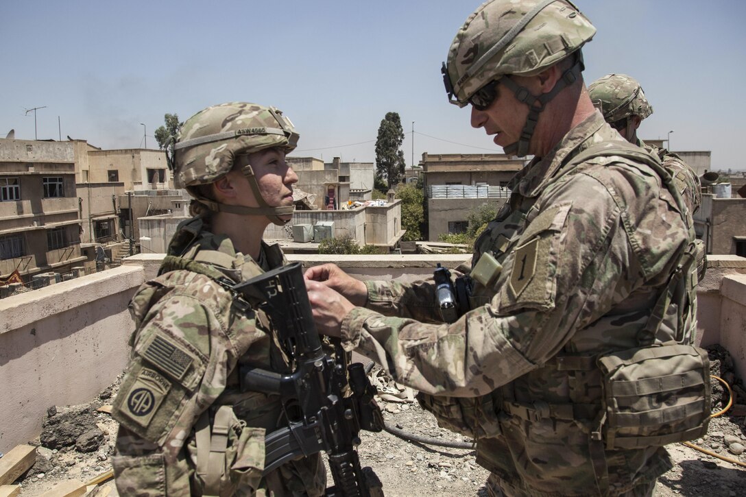 An Army commander promotes a soldier to the rank of sergeant.