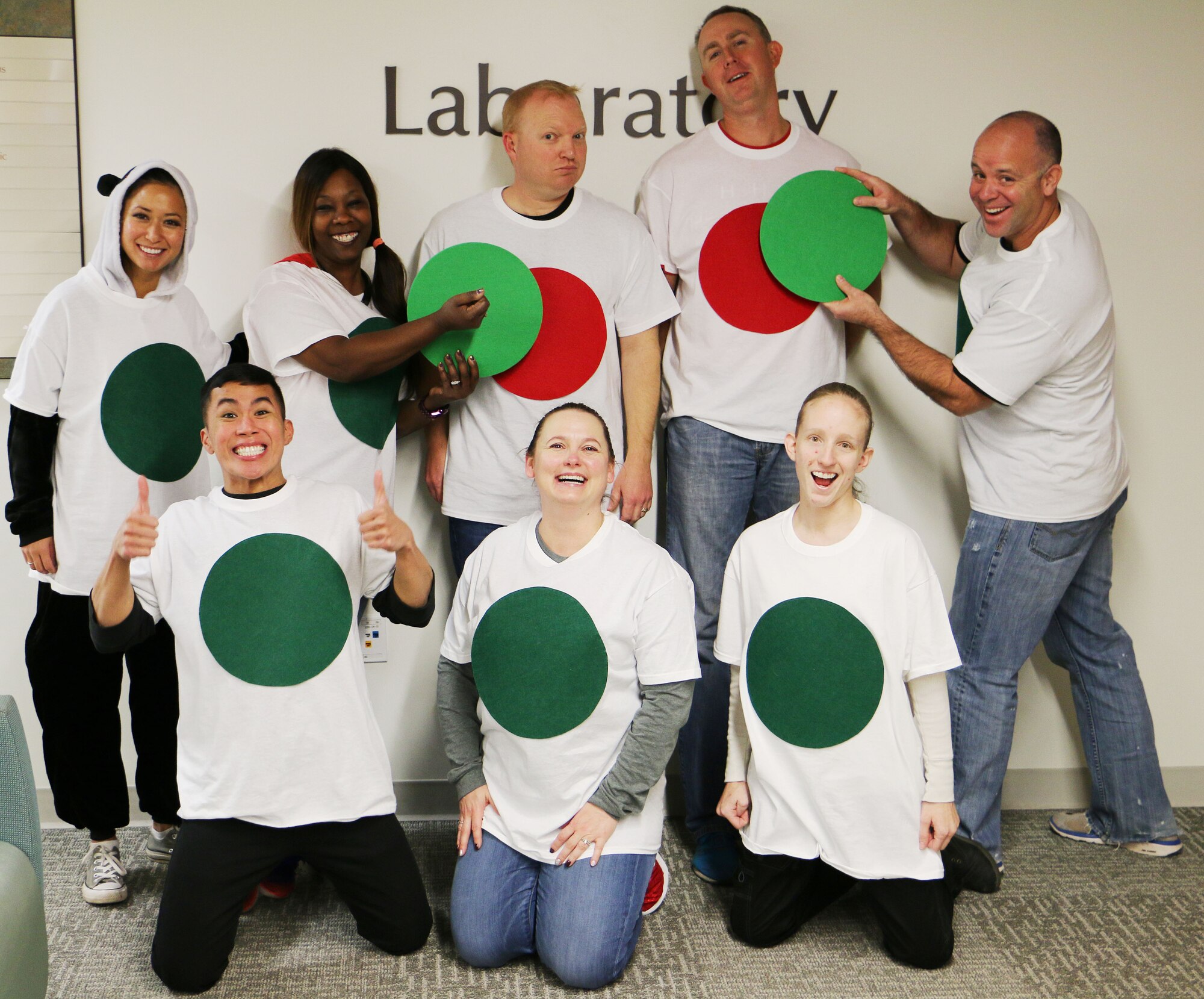 Members of the 21st Medical Group Laboratory at Peterson Air Force Base, Colorado, stand together while dressed as "Red Dots" and "Green Dots" Oct. 31, 2017. The Green Dot program is a violence prevention tool used by the Air Force that reduces power-based interpersonal violence, which includes not only sexual violence, but also domestic violence, dating violence, stalking, child abuse, elder abuse, and bullying. (U.S. Air Force photo by Staff Sgt. Erica Picariello)